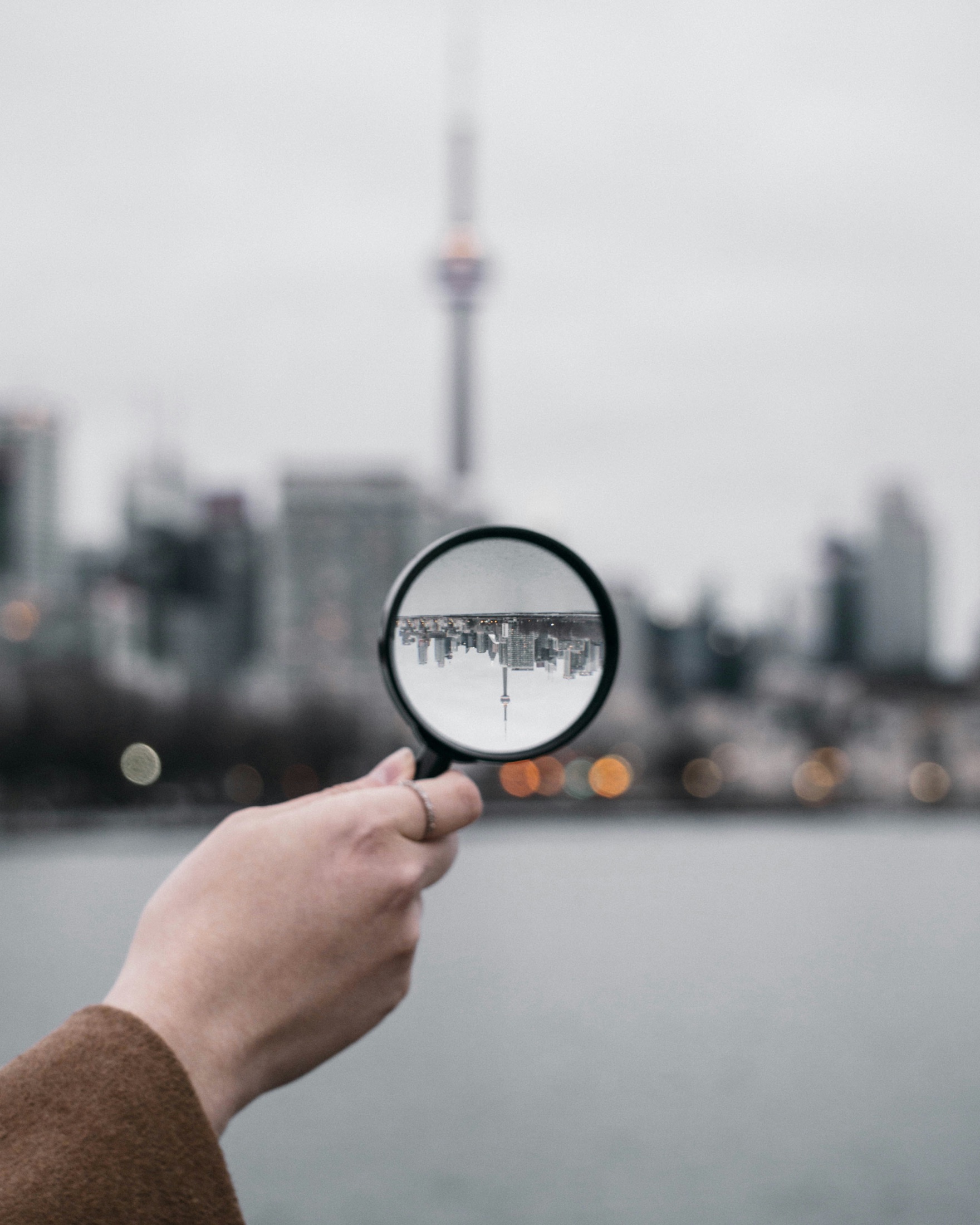 A city viewed through a handheld magnifying glass